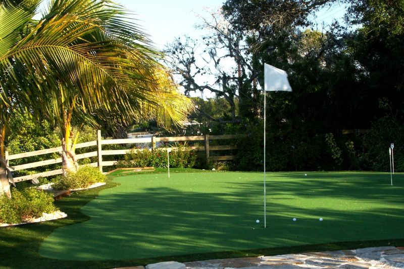 mini golf course with a fence round and balls scattered